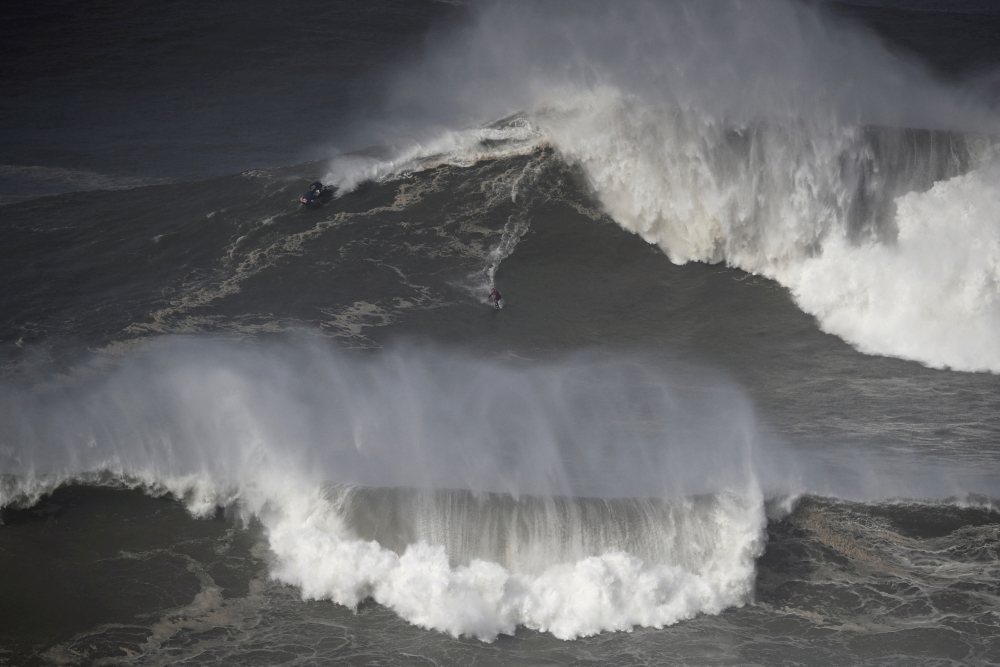 File Photo: A surfer rides a wave in Praia do Norte, Nazare, Portugal, February 25, 2022. (REUTERS/Pedro Nunes)