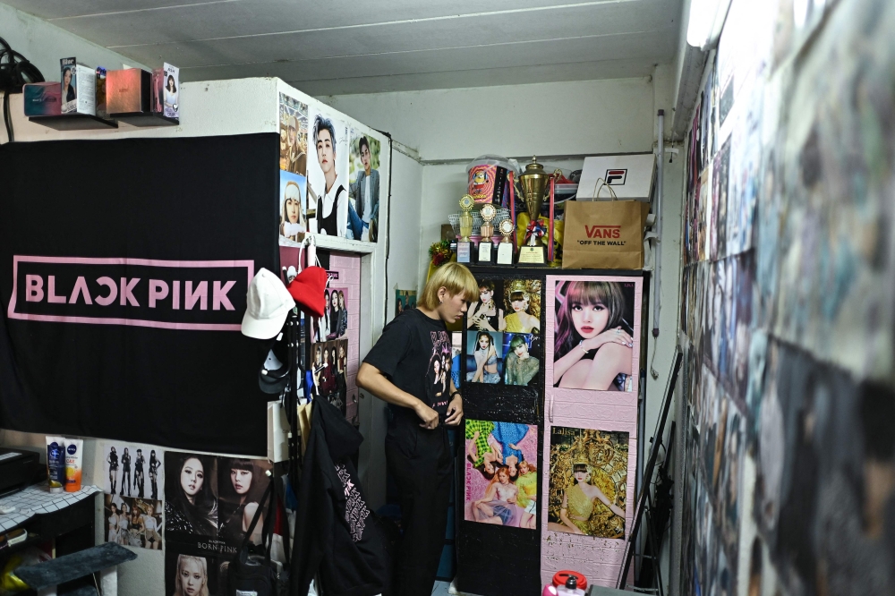 This photograph taken on January 3, 2023 shows social media influencer Nipattanachai 'James' Thepkamdee checking himself in front of a mirror in his bedroom in Bangkok. (Photo by Manan Vatsyayana / AFP) 