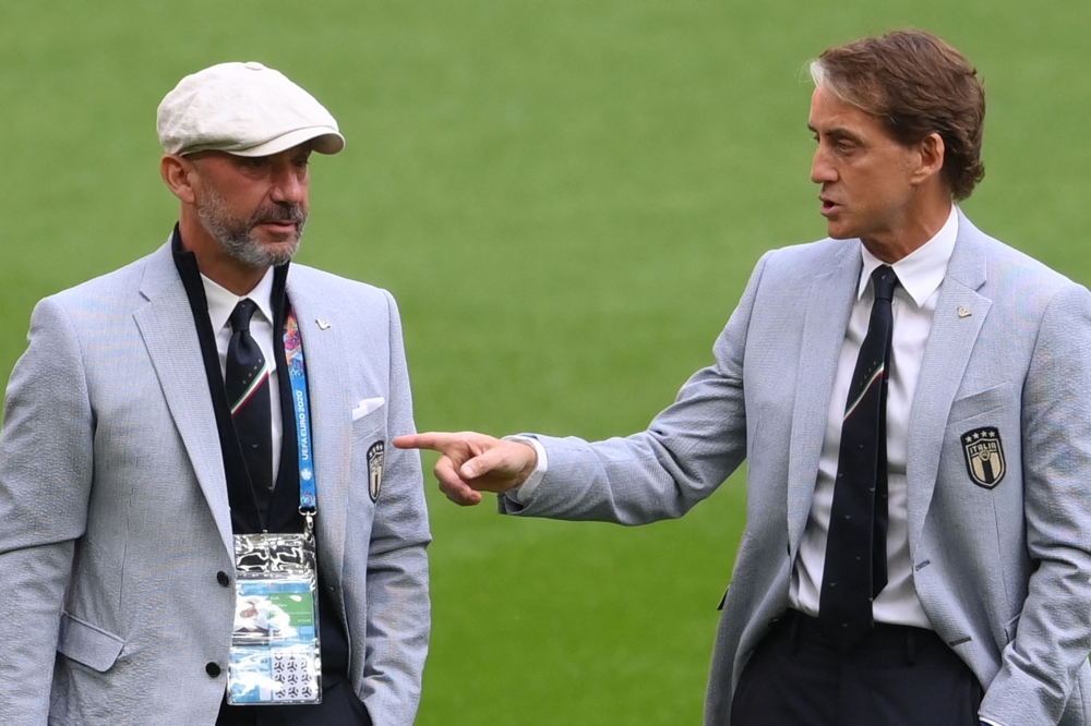 In this file photo taken on June 26, 2021 Italy's coach Roberto Mancini (right) talks with national team staff member Gianluca Vialli (left) ahead of the UEFA EURO 2020 round of 16 match between Italy and Austria at Wembley Stadium in London on June 26, 2021.(Photo by Laurence Griffiths / POOL / AFP)