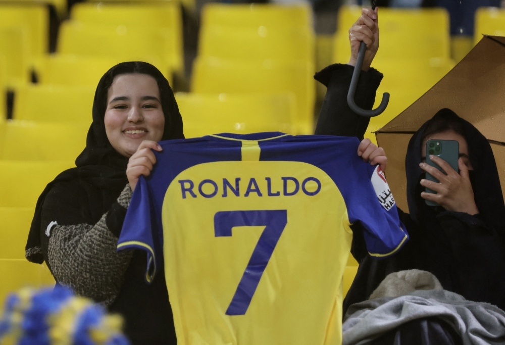 An Al Nassr fan poses holding a shirt with Cristiano Ronaldo's name on the back of it inside the stadium before the Saudi Pro League match between Al Nassr and Al Tai at the Mrsool Park, Riyadh, Saudi Arabia on January 6, 2023.  REUTERS/Ahmed Yosri