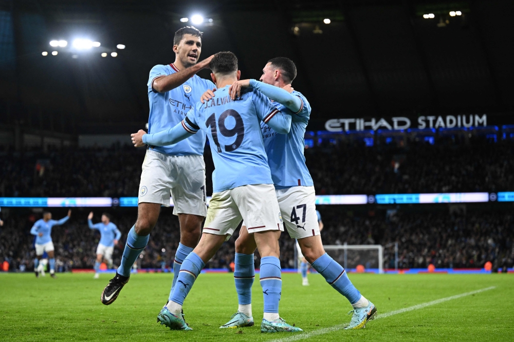 Manchester City's Argentinian striker Julian Alvarez (centre) celebrates with teammates after scoring their second goal from the penalty spot during the English FA Cup third round football match between Manchester City and Chelsea at the Etihad Stadium in Manchester, north-west England, on January 8, 2023. (Photo by Oli SCARFF / AFP)