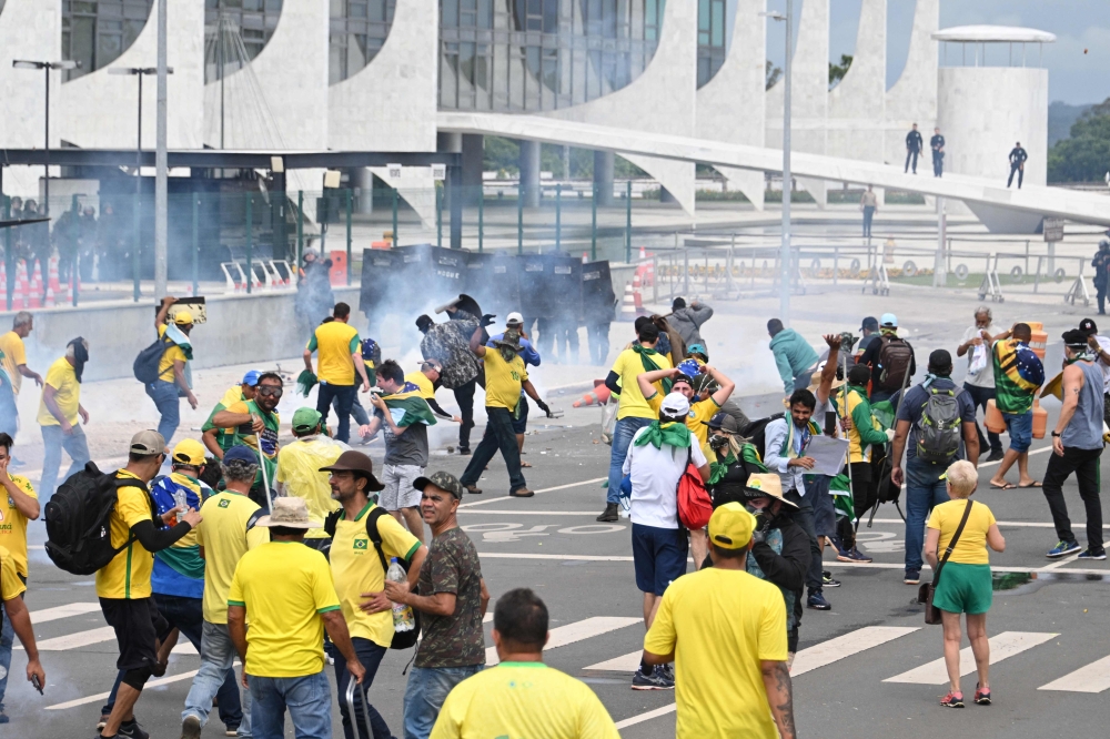 Supporters of Brazilian former President Jair Bolsonaro clash with the police during a demonstration outside the Planalto Palace in Brasilia on January 8, 2023. (Photo by EVARISTO SA / AFP)