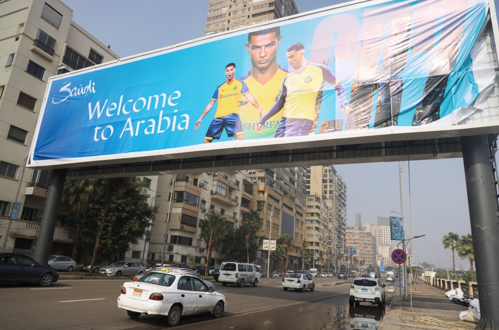 Vehicles pass under a billboard displaying Cristiano Ronaldo wearing a shirt of the Saudi Arabian club Al-Nassr,  in Cairo, Egypt, January 9, 2023. (REUTERS/Amr Abdallah Dalsh)