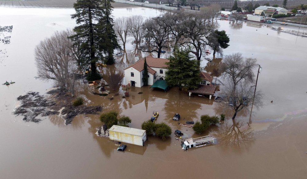 This aerial view shows a flooded home partially underwater in Gilroy, California, on January 9, 2023. - A massive storm called a bomb cyclone