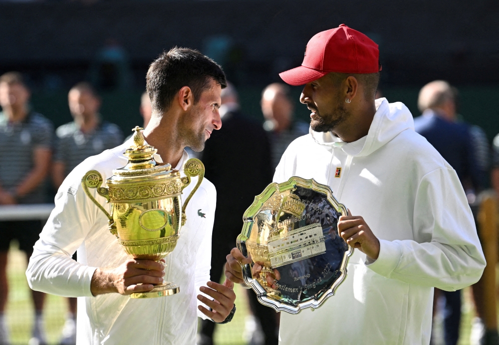 File Photo: Serbia's Novak Djokovic poses with the trophy after winning the Wimbledon men's singles final alongside runner up Australia's Nick Kyrgios, July 2022. (REUTERS/Toby Melville)