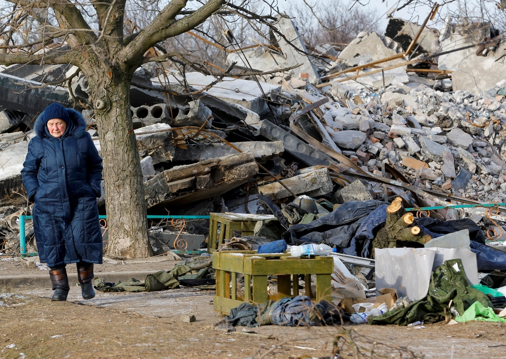 An elderly woman walks near debris of a destroyed building purported to be a vocational college used as temporary accommodation for Russian soldiers, dozens of whom were killed in a Ukrainian missile strike as stated previously by Russia's Defence Ministry, in the course of Russia-Ukraine conflict in Makiivka (Makeyevka), Russian-controlled Ukraine, January 10, 2023. REUTERS/Alexander Ermochenko TPX