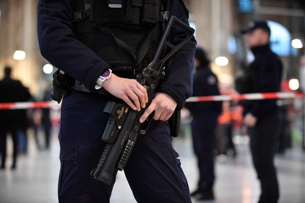 A policeman holds a 40-millimetre rubber defensive bullet launcher LBD (LBD40) to Paris' Gare du Nord train station, after several people were lightly wounded by a man wielding a knife on January 11, 2023. (Photo by Julien De Rosa / AFP)