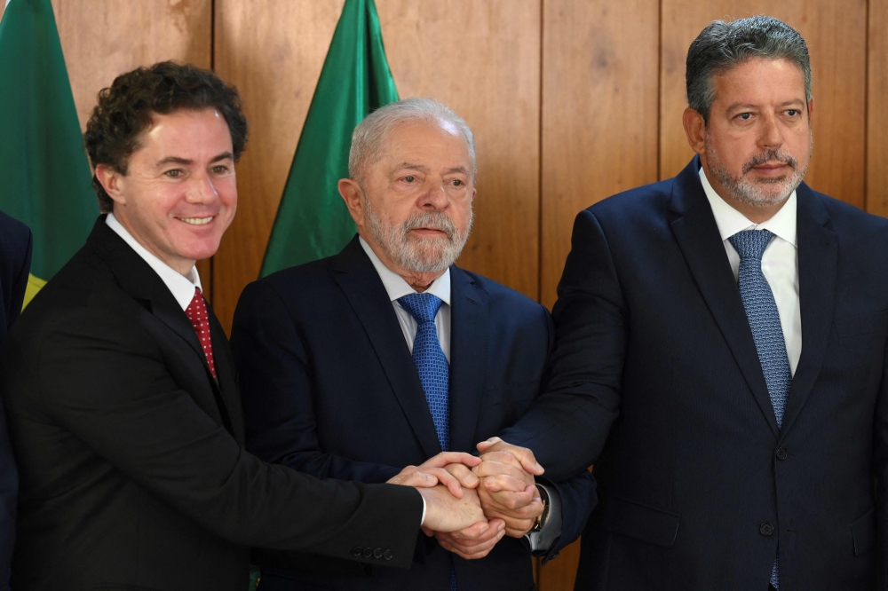 Brazil's President Luiz Inacio Lula da Silva (centre), Senate President Veneziano Vital do Rego (left) and Lower House's President Arthur Lira pose for a picture during a meeting with parliamentarians who submitted the document approving the decree of federal intervention, in the Public Security Secretariat at Planalto Palace, Brasilia, on January 11, 2023. (Photo by EVARISTO SA / AFP)