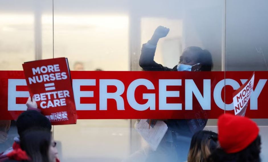 A hospital worker raises a fist as NYSNA nurses walk off the job, to go on strike at Mount Sinai Hospital in New York City, US, January 9, 2023. (REUTERS/Andrew Kelly)
