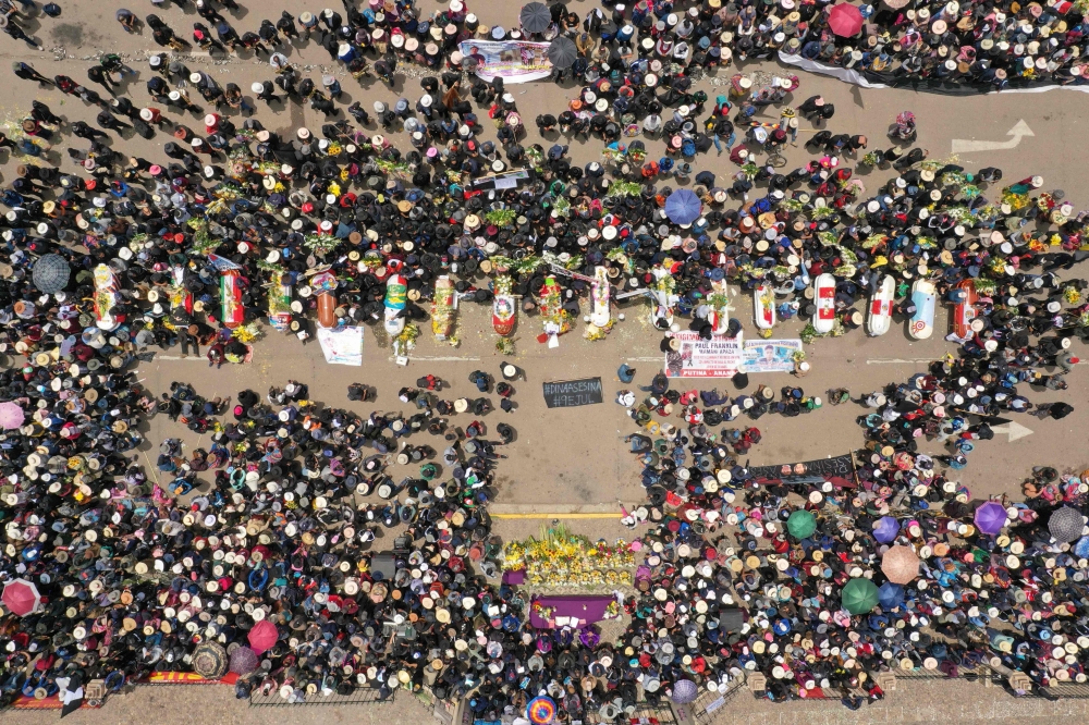Aerial view of relatives and friends of the victims of clashes with the Peruvian police puting their coffins in the main plaza of the Andean city of Juliaca, southern Peru, on January 11, 2023. (Photo by Juan Carlos Cisneros / AFP)