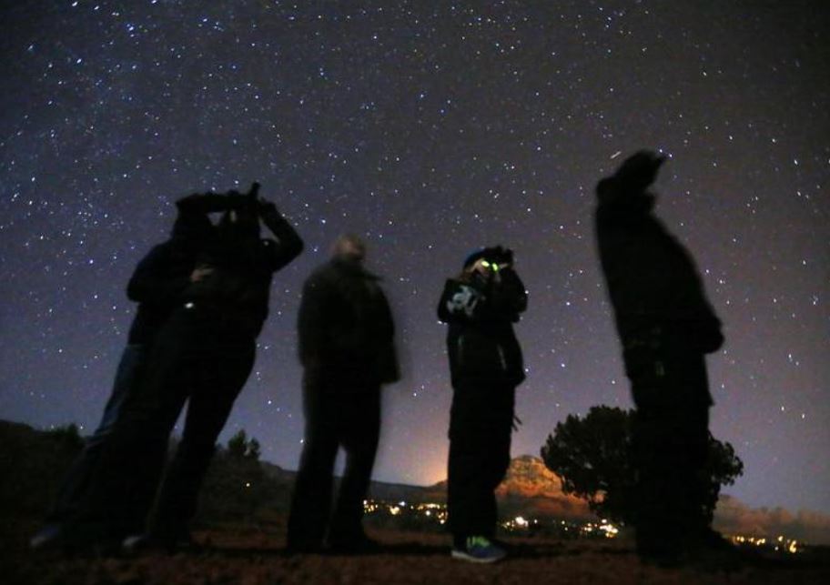 File Photo: People use night vision goggles to look at the night sky during an Unidentified Flying Object (UFO) tour in the desert outside Sedona, Arizona, February 14, 2013. (REUTERS/Mike Blake)