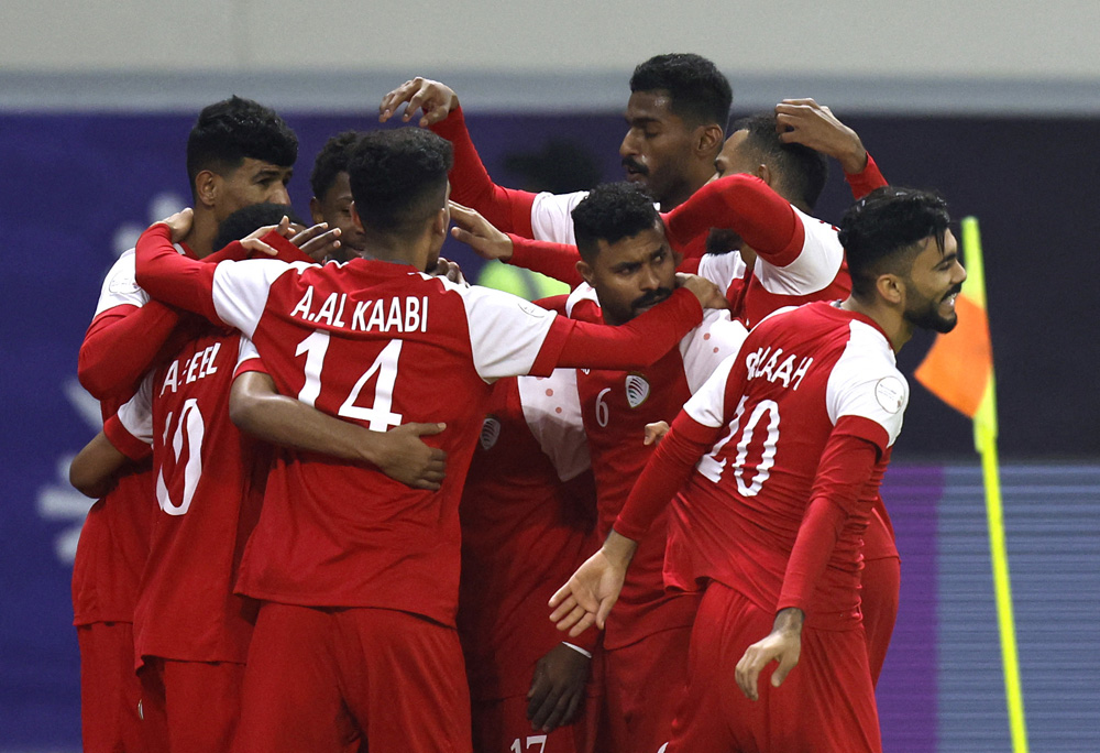 Oman’s players celebrate after scoring their first goal against Saudi Arabia, yesterday. REUTERS 