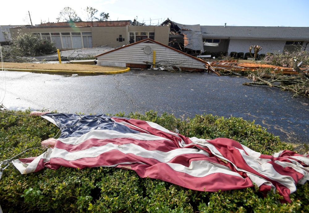 The American flag lies in the shrubs in front of the storm damaged Selma Country Club after a tornado ripped through Selma, Alabama, US, January 12, 2023. (Mickey Welsh/USA Today Network via REUTERS)