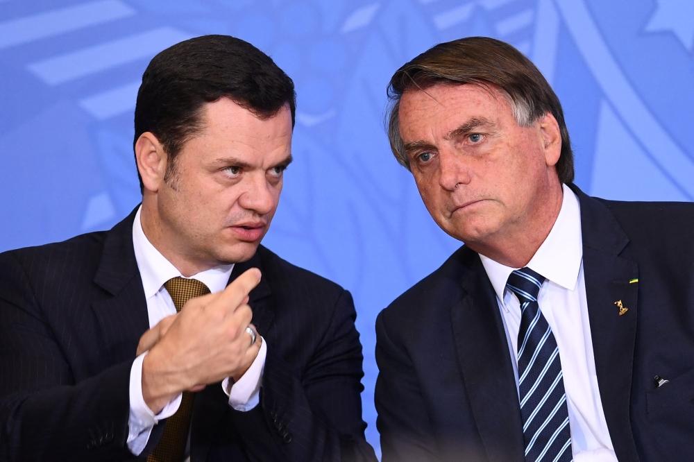 File photograph taken on June 27, 2022, then Brazilian President Jair Bolsonaro (L) and his Minister of Justice Anderson Torres during an event. (Photo by Evaristo SA / AFP)
