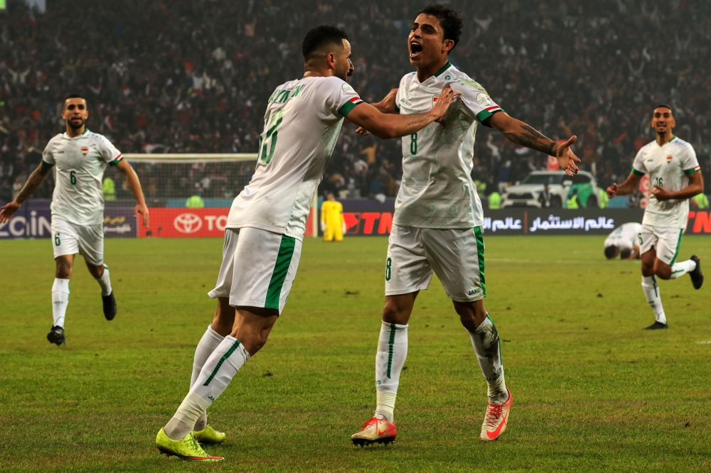 Iraq's midfielder Ibrahim Bayesh (R, #8) celebrates after scoring his team's first goal during the Arabian Gulf Cup semi-final football match between Iraq and Qatar at the Basra International Stadium in Iraq's southern city on January 16, 2023. (Photo by AHMAD AL-RUBAYE / AFP