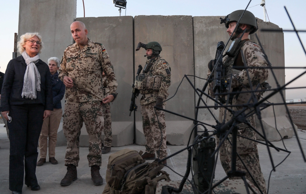 This file photo taken on January 9, 2022 shows German Defence Minister Christine Lambrecht talking to soldiers as she visited German armed forces in Arbil, the capital of the autonomous Kurdish region in northern Iraq.  (Photo by SAFIN HAMED / AFP)