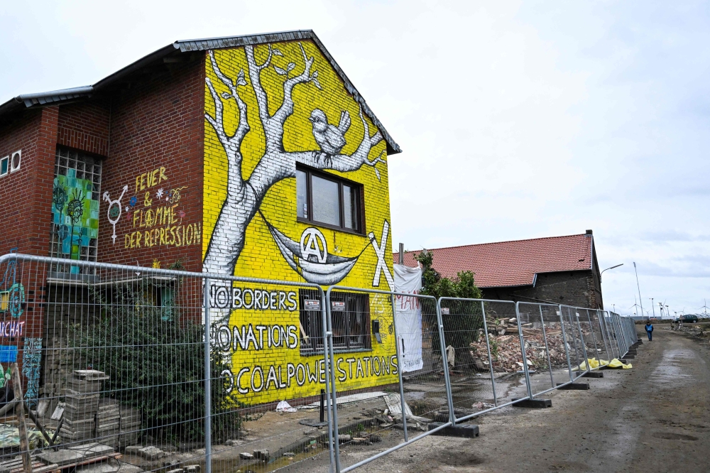 Houses and the remains of the farm that belonged to Eckhard Heukamp are pictured in the village of Luetzerath, western Germany, that is demolished to make way for an open-air coal mine extension on January 16, 2023. (Photo by INA FASSBENDER / AFP)