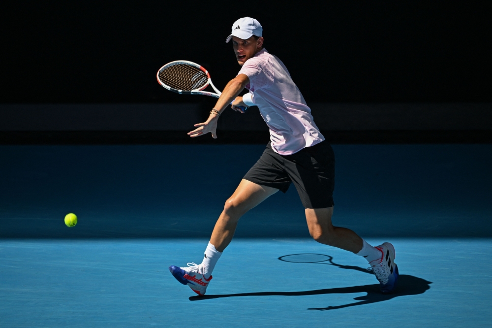Austria's Dominic Thiem hits a return against Russia's Andrey Rublev during their men's singles match on day two of the Australian Open tennis tournament in Melbourne on January 17, 2023. (Photo by ANTHONY WALLACE / AFP)