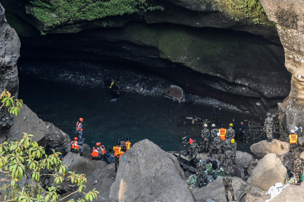 Rescue teams search for victims at the site of the Yeti Airlines plane crash, in Pokhara on January 17, 2023. (Photo by PRAKASH MATHEMA / AFP)