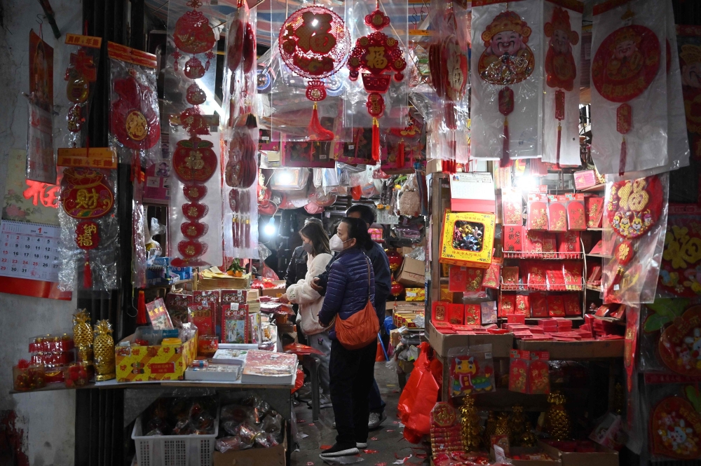 People shop for Lunar New Year decorations in the southern Chinese enclave of Macau ahead of the New Year of the Rabbit on January 17, 2023. (Photo by Peter Parks / AFP)