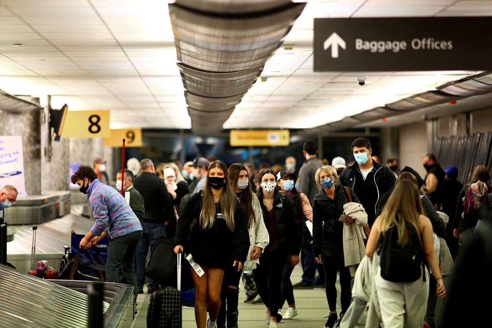 Travelers wearing protective face masks to prevent the spread of the coronavirus disease (COVID-19) reclaim their luggage at the airport in Denver, Colorado, US, on November 24, 2020. File Photo / Reuters
