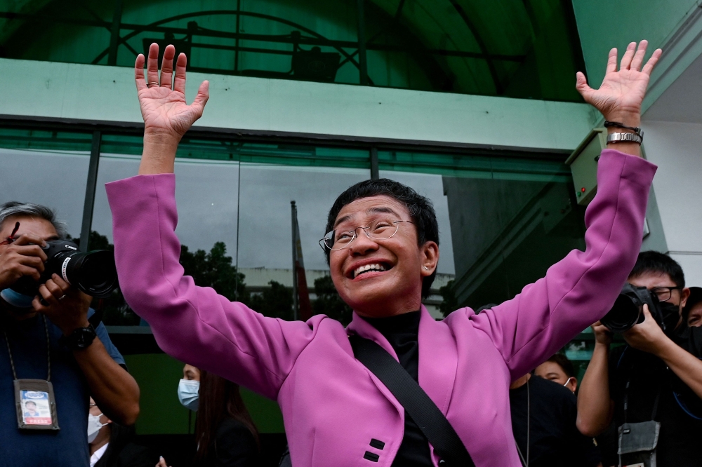 Nobel Laureate Maria Ressa gestures after she was acquitted of the tax evasion cases against her at the Court of Tax Appeals in Quezon City, Metro Manila on January 18, 2023. (Photo by JAM STA ROSA / AFP)