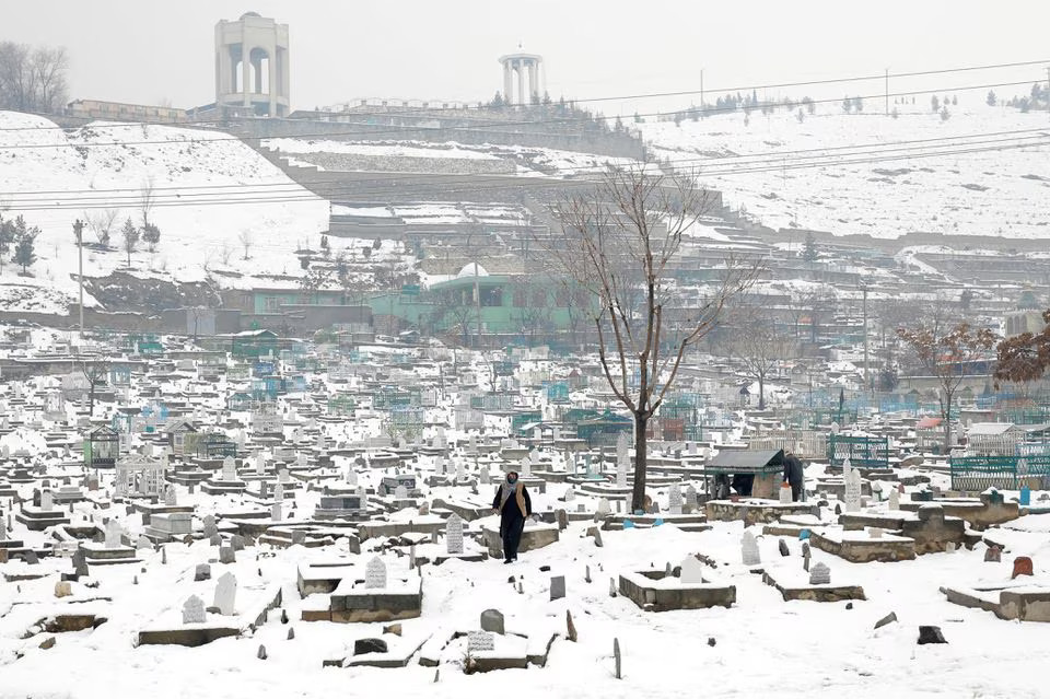An Afghan man walks on a snow-covered cemetery in Kabul, Afghanistan, January 11, 2023. REUTERS/Ali Khara/File Photo







