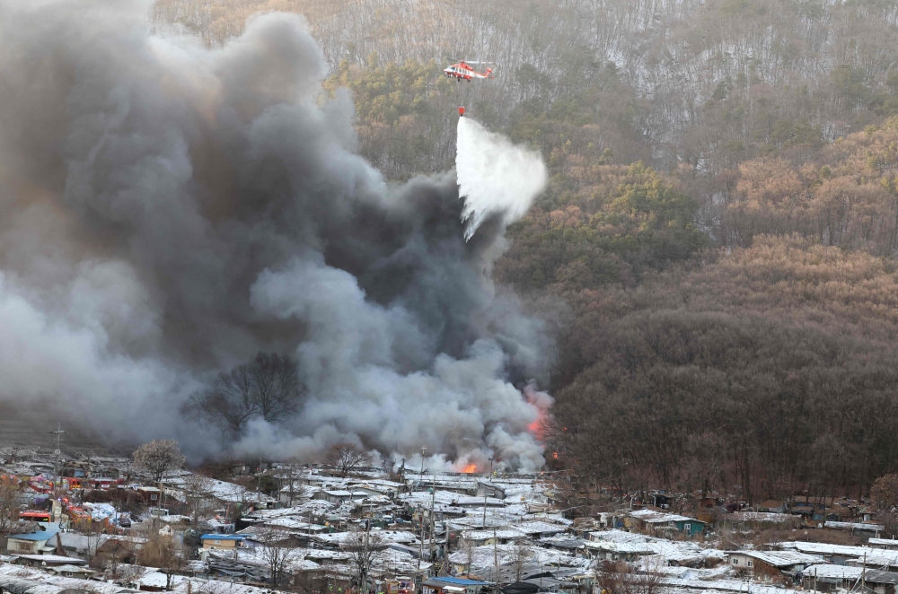 Firefighters try to extinguish a fire at the Guryong village, one of South Korea's last remaining slums, in southern Seoul on January 20, 2023. Photo by YONHAP / AFP