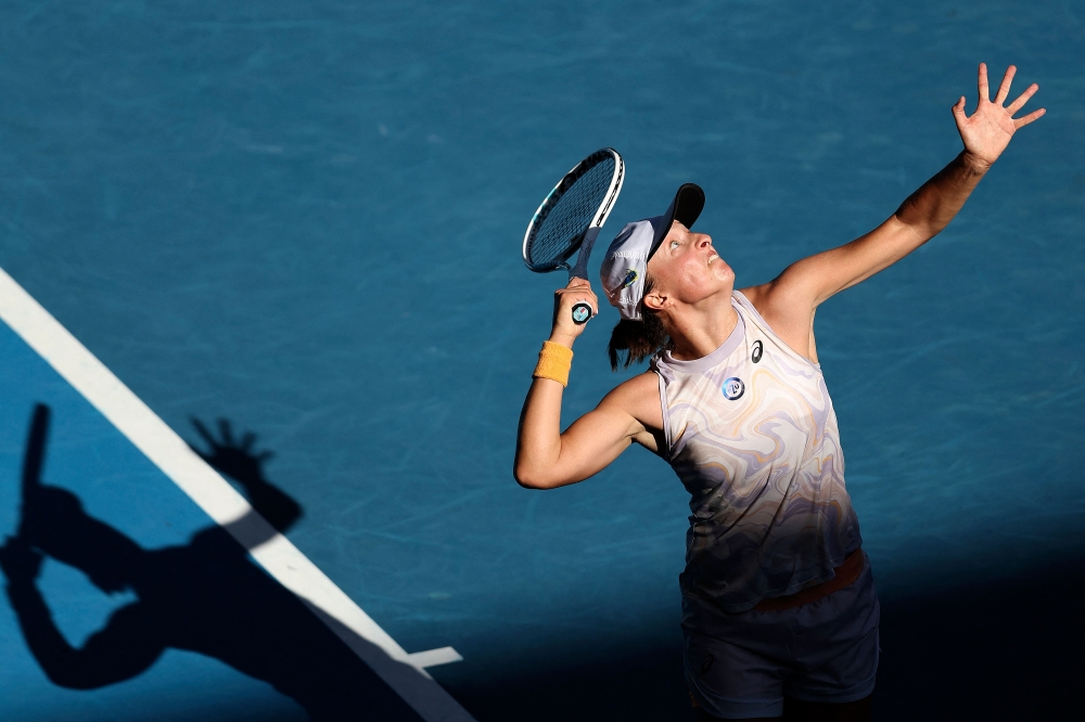 Poland's Iga Swiatek serves against Spain's Cristina Bucsa during their women's singles match on day five of the Australian Open tennis tournament in Melbourne on January 20, 2023. (Photo by Martin KEEP / AFP)