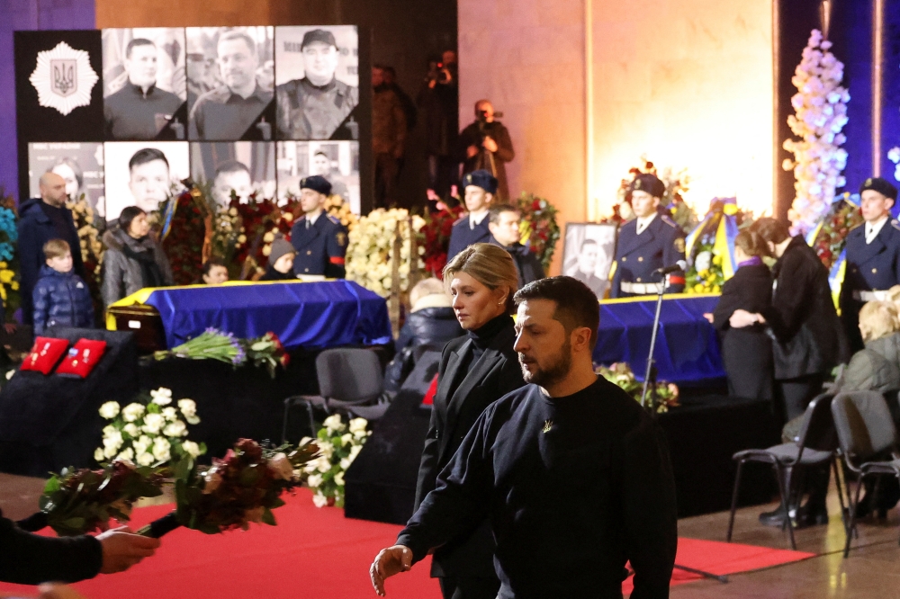 Ukraine's President Volodymyr Zelenskiy and first lady Olena Zelenska attend a memorial ceremony for Ukrainian Interior Minister Denys Monastyrskyi, his deputy and officials who died in the helicopter crash near Kyiv, in Kyiv, Ukraine, January 21, 2023. Reuters/Nacho Doce
