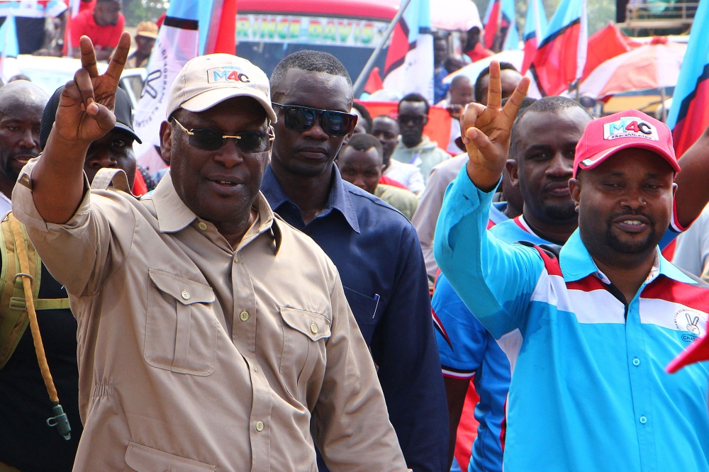 Freeman Mbowe (L), Chairman Tanzania's main opposition party Chadema, flashes a victory sign during party's first political rally after an imposed ban in 2016 was lifted, at Furahisha Grounds in Mwanza, on January 21, 2023. (Photo by MICHAEL JAMSON / AFP)
