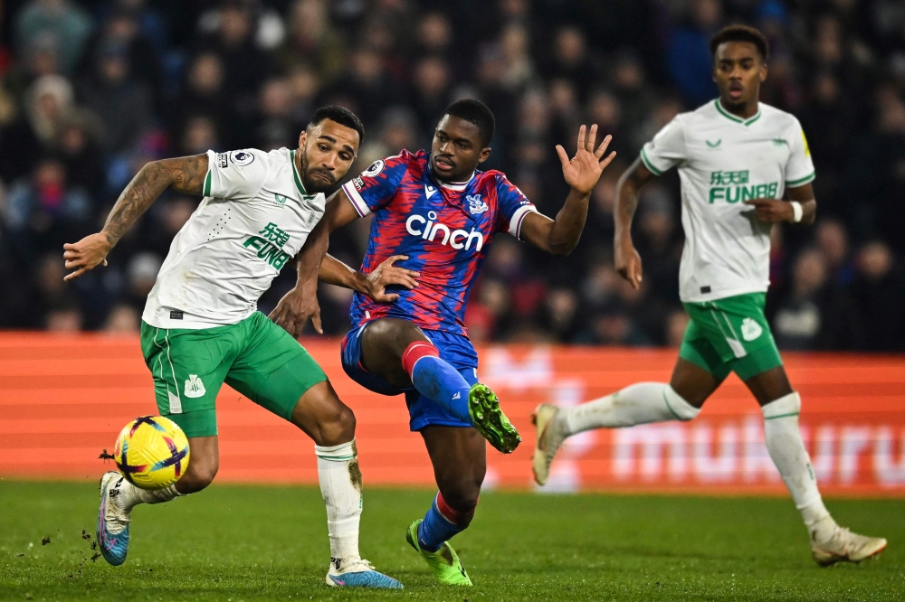 Newcastle United's Callum Wilson (left) fights for the ball with Crystal Palace's Cheick Doucoure during the English Premier League match between Crystal Palace and Newcastle United at Selhurst Park in south London on January 21, 2023. (Photo by Ben Stansall / AFP)