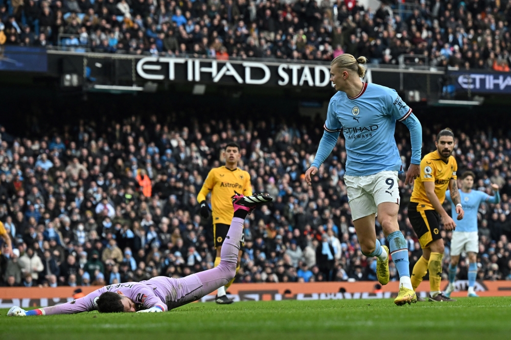 Manchester City's Erling Haaland (right) celebrates past Wolverhampton Wanderers' goalkeeper Jose Sa after scoring his team third goal during the English Premier League match between Manchester City and Wolverhampton Wanderers at the Etihad Stadium in Manchester, north west England, on January 22, 2023. (Photo by Paul ELLIS / AFP)