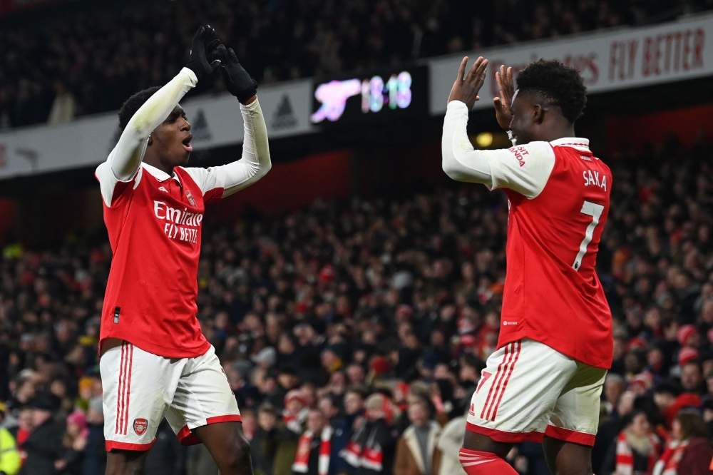 Arsenal's English striker Eddie Nketiah (left) celebrates with Arsenal's English midfielder Bukayo Saka after scoring their third goal during the English Premier League match between Arsenal and Manchester United at the Emirates Stadium in London on January 22, 2023. (Photo by Glyn KIRK / AFP)