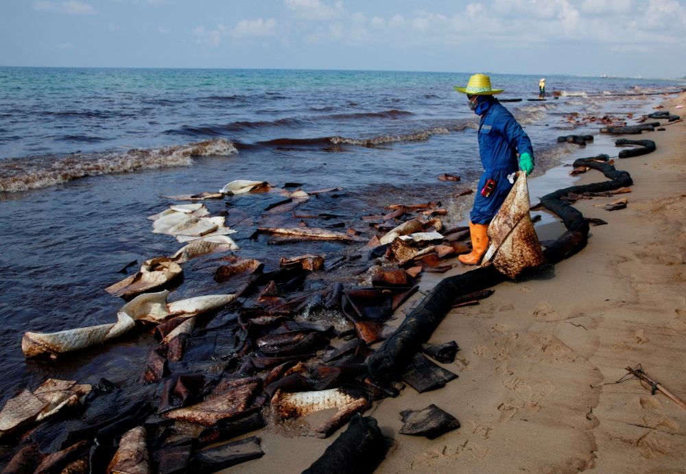 A worker cleans oil spills caused by a leak from an undersea pipeline 20 km (12.4 miles) off Thailand's eastern coast at Mae Ramphueng beach in Rayong province, Thailand, January 29, 2022. REUTERS/Soe Zeya Tun/File Photo