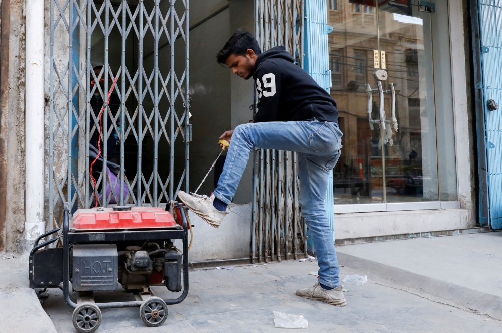 A man starts a generator outside his shop during a country-wide power breakdown in Karachi, Pakistan January 23, 2023. File Photo: Reuters/Akhtar Soomro
