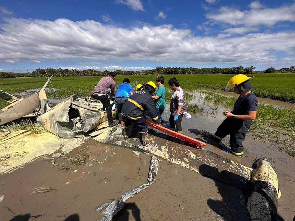 A handout photo from the Bureau of Fire Protection Region II taken and released on January 25, 2023, shows rescuers retrieving a body from a crashed plane in Pilar, Bataan, where two Philippine air force aviators were killed. (Photo by Handout / Bureau of Fire Protection Region II / AFP) 