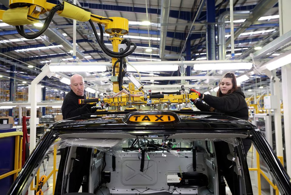 Workers fit a roof panel on the TX electric taxi production line inside the LEVC (London Electric Vehicle Company) factory in Coventry, Britain, January 18, 2023. File Photo: Reuters/Phil Noble





