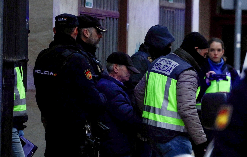 Spanish national police officers lead away a 74-year-old man under arrest on suspicion of being the sender of letter-bombs in November and December to the Ukrainian and US embassies and several institutions in Spain, in Miranda de Ebro, Spain on January 25, 2023. REUTERS/Vincent West
