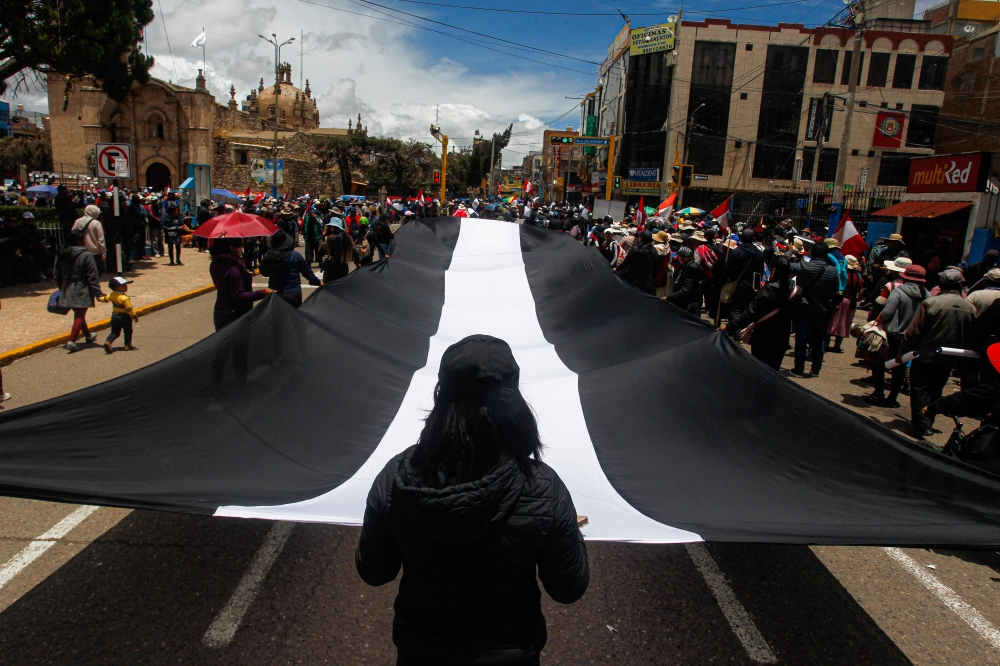 Demonstrators hold a protest against the government of Peruvian President Dina Boluarte and to demand her resignation, in Juliaca, southern Peru, on January 27, 2023. - Peru's embattled President Dina Boluarte on Friday urged Congress to advance elections slated for April 2024 to December 2023 as protests against her leadership that have left dozens dead continue. Peru has been embroiled in a political crisis with near-daily protests since December 7 when former president Pedro Castillo was arrested after attempting to dissolve parliament and rule by decree. (Photo by Juan Carlos CISNEROS / AFP)