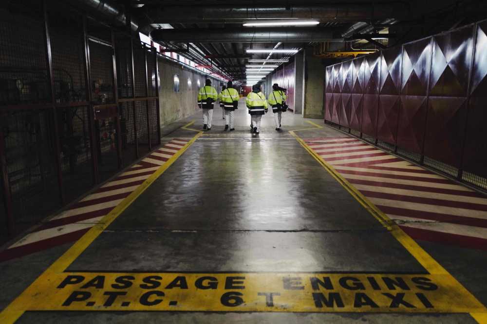 This photograph taken on January 26, 2023, shows people walking in the manufacturing workshop Georges Besse 1, an Uranium enrichment site at the Tricastin nuclear power plant in Saint-Paul-Trois-Chateau, southern France. (Photo by OLIVIER CHASSIGNOLE / AFP)
