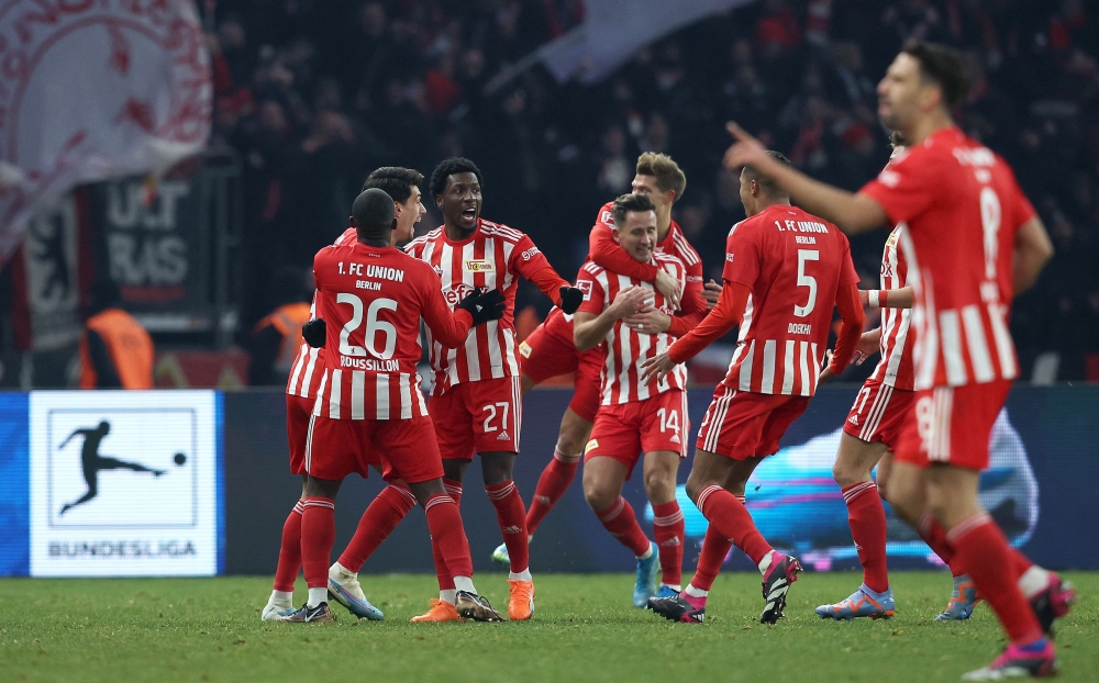 Union Berlin's Sheraldo Becker (third left) celebrates scoring his team's second goal with team mates during the German Bundesliga match between Hertha Berlin and 1 FC Union Berlin at the Olympic Stadium in Berlin on January 28, 2023. (Photo by Ronny Hartmann / AFP)