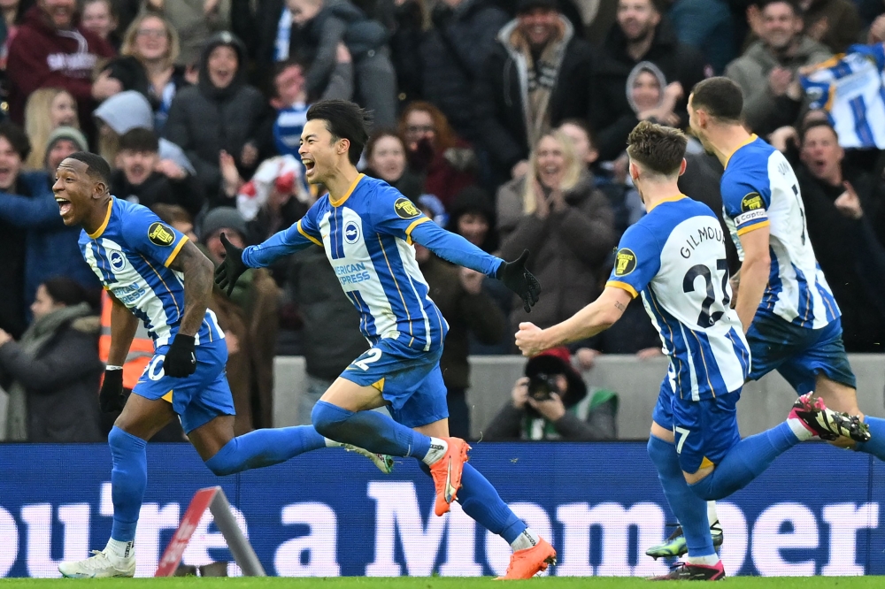 Brighton's Japanese midfielder Kaoru Mitoma (centre) celebrates with teammates after scoring their second goal during the English FA Cup fourth round football match between Brighton & Hove Albion and Liverpool at the Amex stadium in Brighton, on the south coast of England on January 29, 2023.  (Photo by Glyn KIRK / AFP)