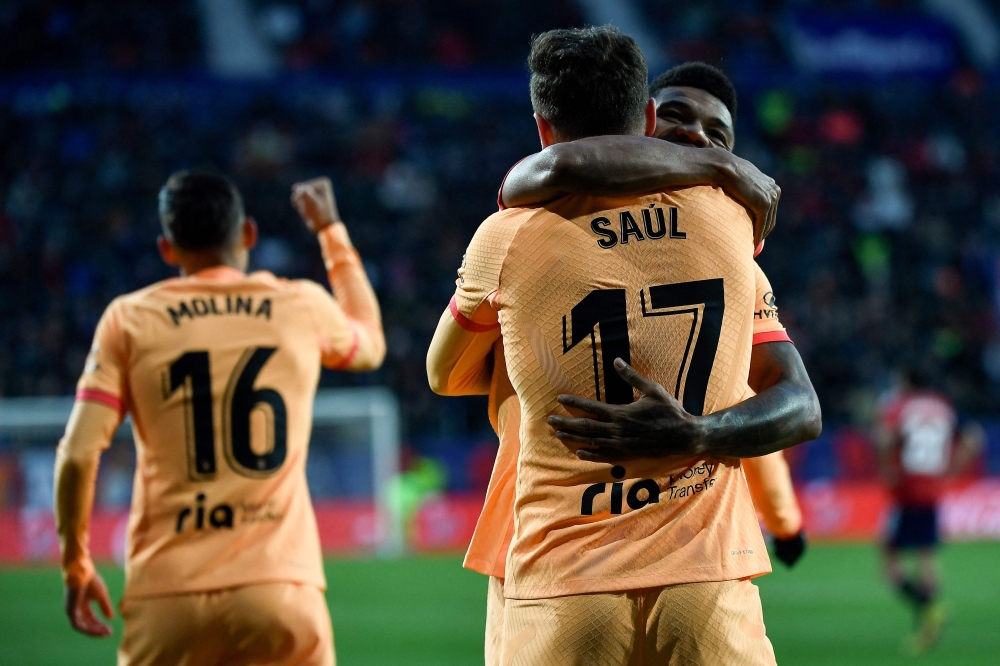 Atletico Madrid's midfielder Saul Niguez celebrates with teammates after scoring his team's first goal during the Spanish league match between CA Osasuna and Club Atletico de Madrid at El Sadar stadium in Pamplona on January 29, 2023. (Photo by ANDER GILLENEA / AFP)