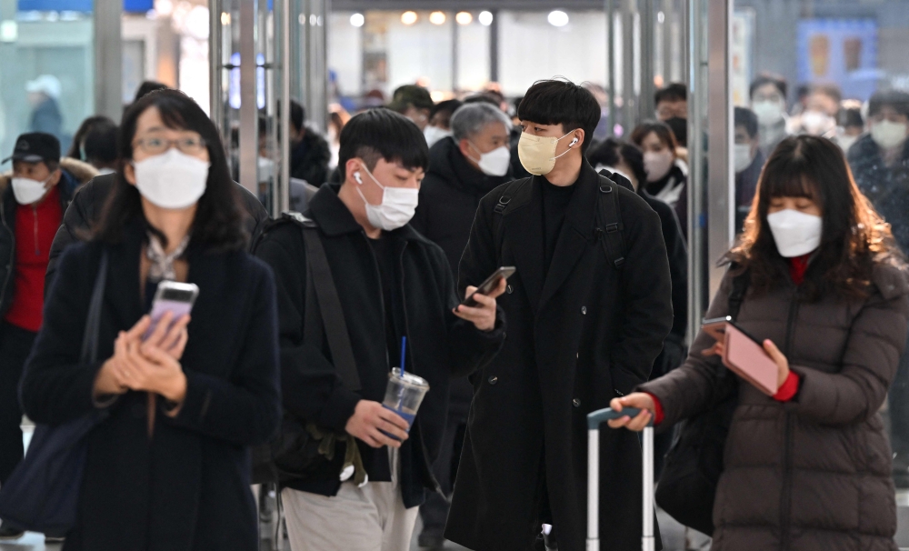 People wearing face masks make their way at Seoul railway station in Seoul on January 30, 2023, after South Korea lifted its indoor mask mandate as Covid cases dwindle. Photo by Jung Yeon-je / AFP