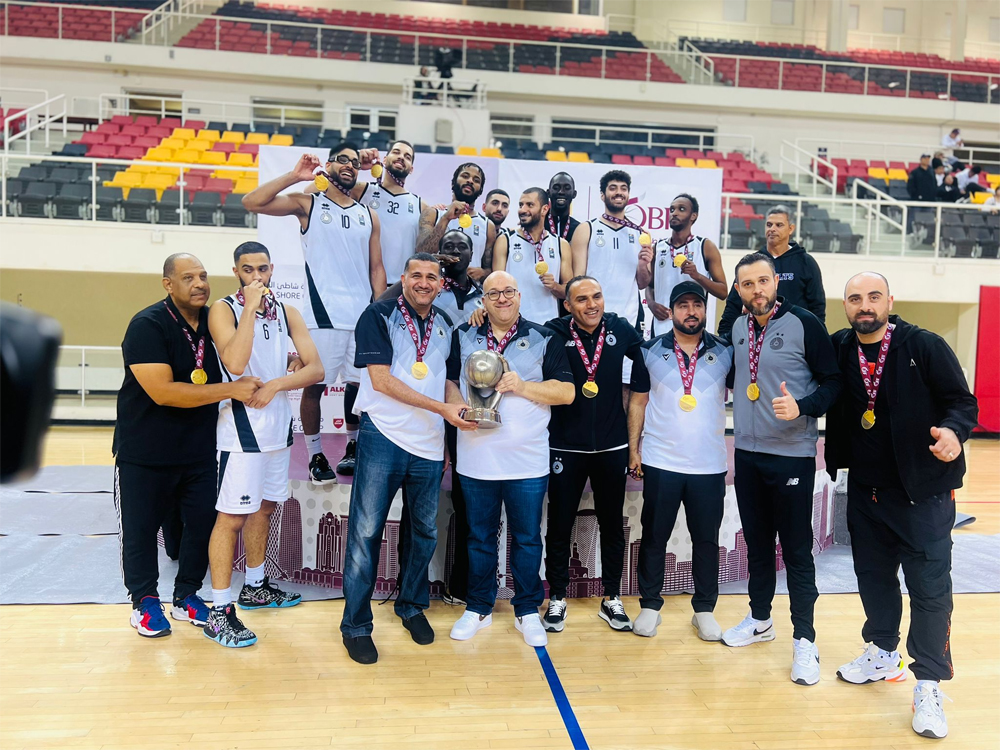 Al Sadd's players and officials celebrate with the trophy.