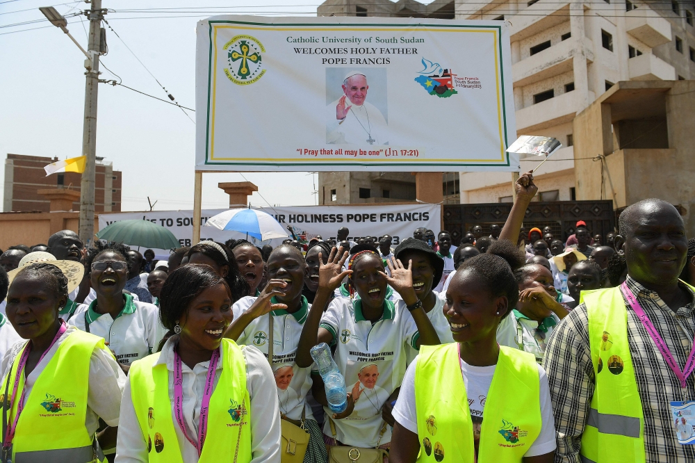 Attendees cheer ahead of the arrival of Pope Francis at the Juba International Airport in Juba, South Sudan, on February 3, 2023. - Pope Francis is scheduled to land in Juba, in the first visit to South Sudan by a pope since the predominantly Christian nation gained independence from Muslim-majority Sudan in 2011 after decades of bloody struggle. (Photo by SIMON MAINA / AFP)
