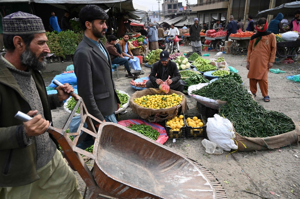 People buy vegetable at a market in Islamabad on February 3, 2023. - Pakistan's Prime Minister Shehbaz Sharif said February 3 the government would have to agree to IMF bailout conditions that are 