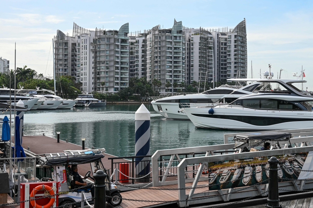 This picture taken on February 1, 2023 shows Sentosa Cove private residential housing next to yachts docked at One 15 Marina Sentosa Cove in Singapore. (Photo by Roslan RAHMAN / AFP)