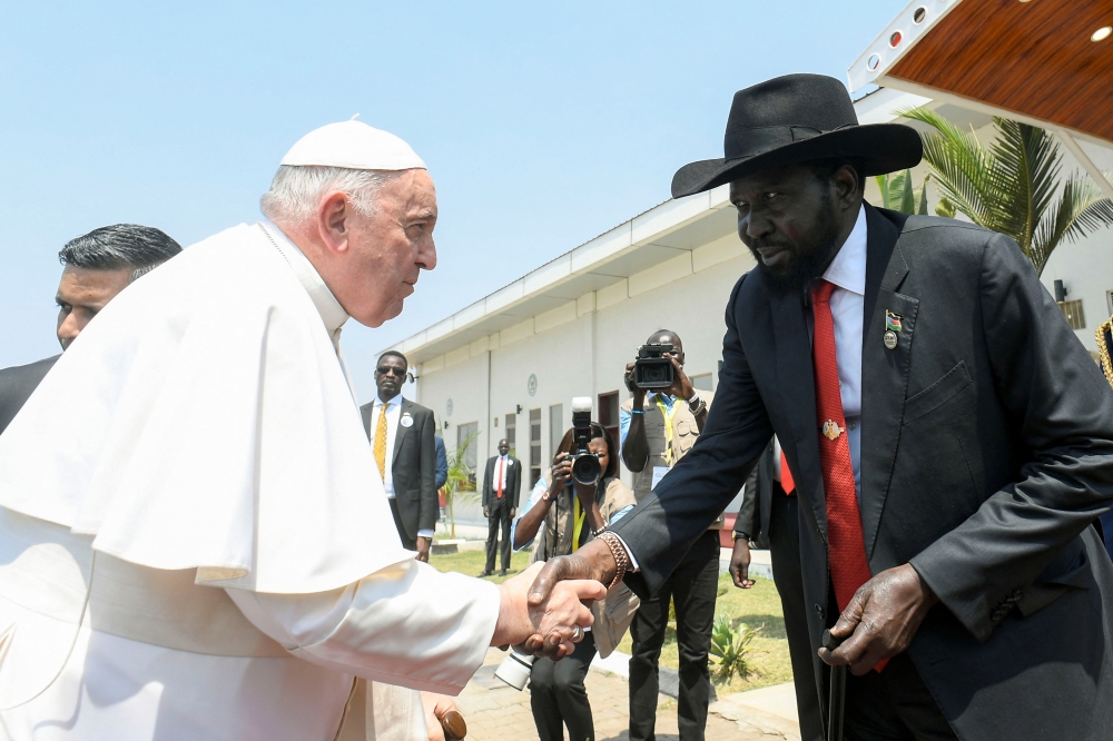 This handout photo taken and released on February 5, 2023 by the Vatican Media shows the President of South Sudan Salva Kiir greeting Pope Francis before the Pope departs South Sudan, at the Juba International Airport in Juba.  (Photo by VATICAN MEDIA / AFP)